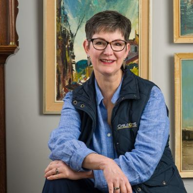 Woman in front of paintings and grandfather clock