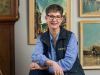 Woman in front of paintings and grandfather clock