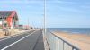 Resurfaced path in front of Sideshore, with the beach to the right and blue sky above