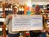 Patrick Agnew (left), Devon Young Carers Service Manager, receives a cheque from Wine World owner Ju